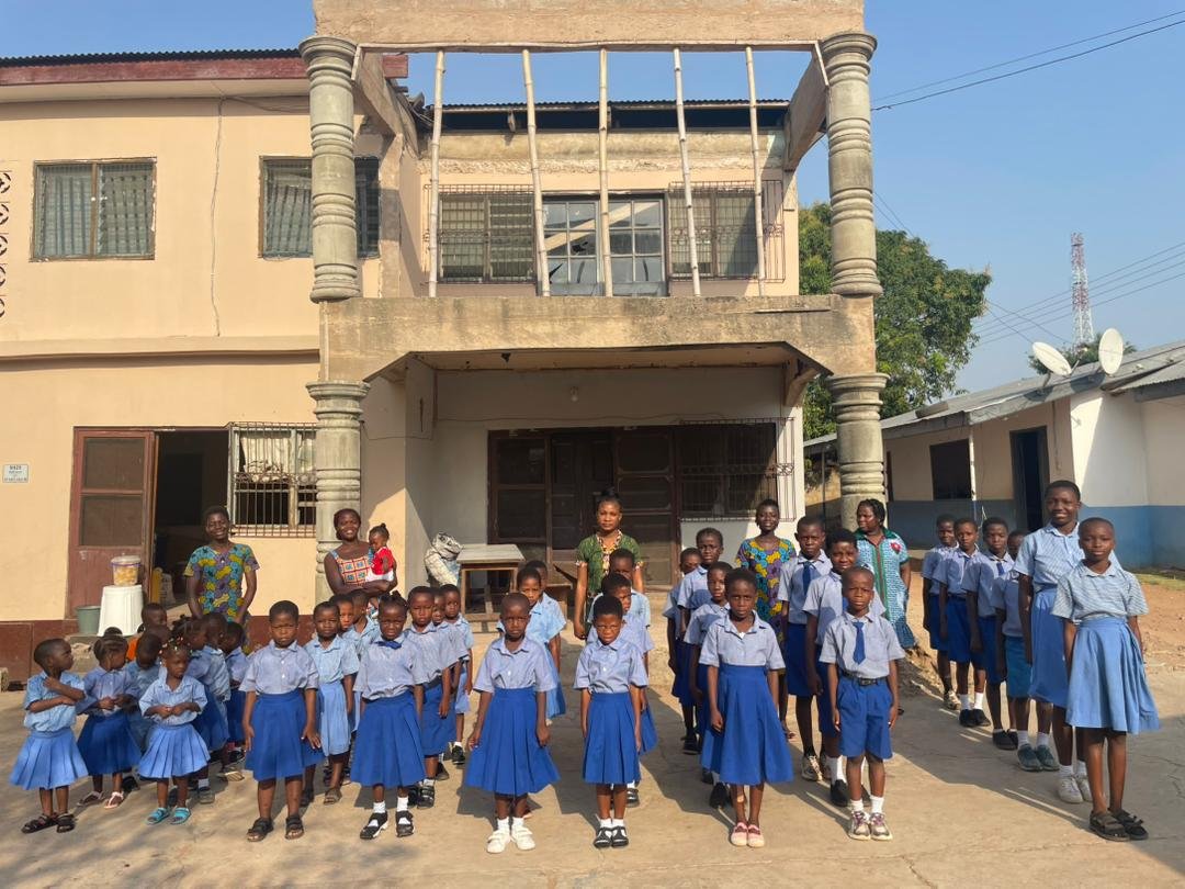 Students and staff gathered outside a school supported by Ryvanz-Mia Charity