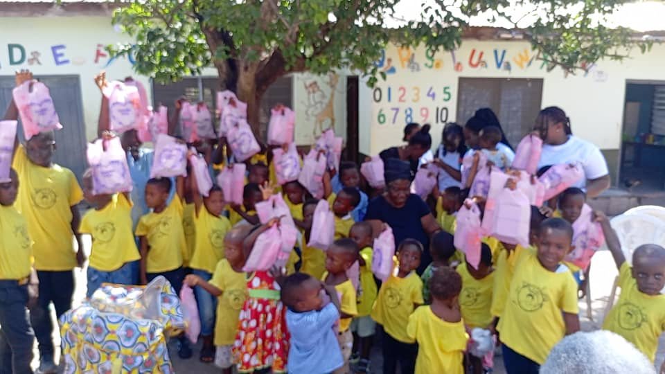Children and supporters holding donated school bags