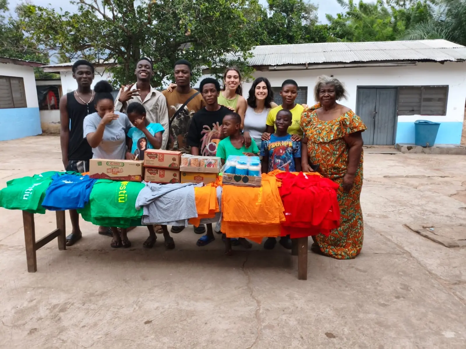 Volunteers, children and community members with donated clothing and supplies
