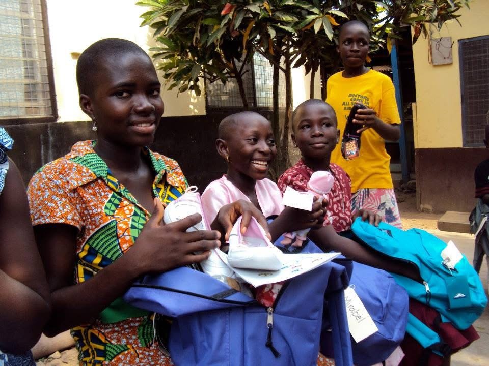 Children receiving school supplies through a Ryvanz-Mia Charity education program