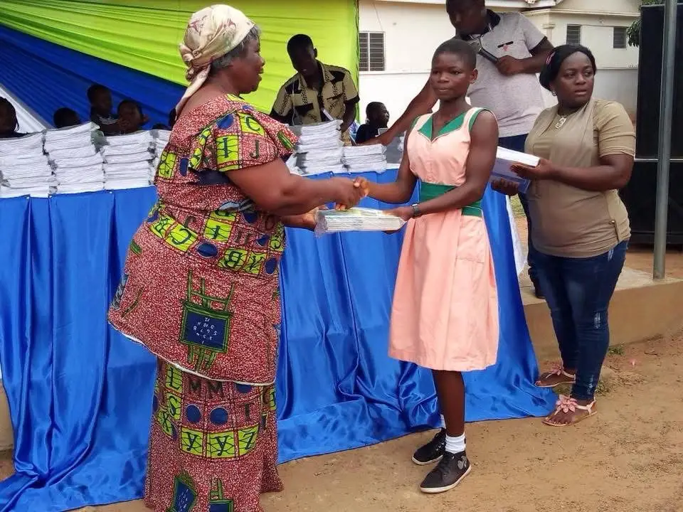 A student receiving exercise books during a school supplies distribution
